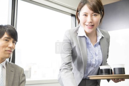 Téléchargez les photos : Jeune asiatique femme d'affaires avec des tasses à café au bureau - en image libre de droit