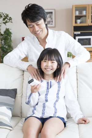 Téléchargez les photos : Asiatique père et fille avec télécommande - en image libre de droit