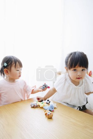 Photo for Closeup shot of cute Japanese girls playing with toys at home interior - Royalty Free Image