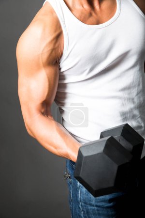 man in shirt with dumbbell on background