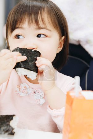 Téléchargez les photos : Fermer asiatique fille manger sushi - en image libre de droit