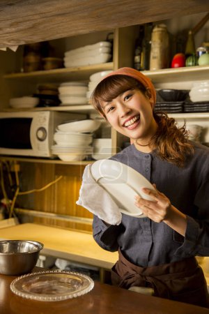 Foto de Mujer asiática camarera limpiando plato - Imagen libre de derechos