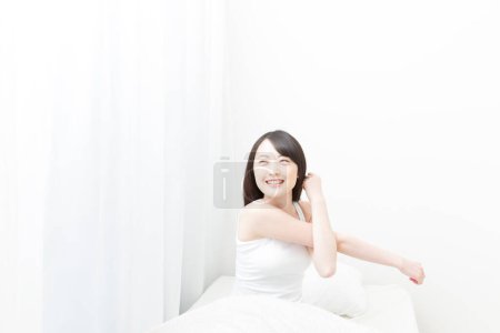 Foto de Retrato hermoso asiático joven mujer feliz sonrisa streching en cama - Imagen libre de derechos