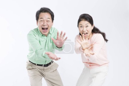 Foto de Asiático senior pareja haciendo monstruos mandíbulas gesto estudio disparo - Imagen libre de derechos