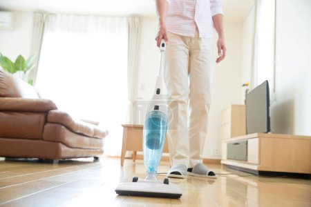 Photo for Young man  with vacuum cleaner  at home - Royalty Free Image
