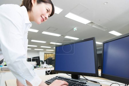 Téléchargez les photos : Femme travaillant sur ordinateur au bureau - en image libre de droit