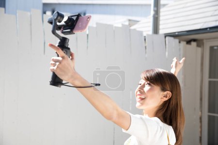 Photo for Young beautiful asian woman blogger filming video - Royalty Free Image
