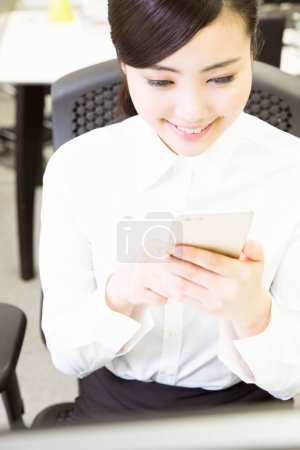 Photo for Young asian businesswoman  using  smartphone in office - Royalty Free Image