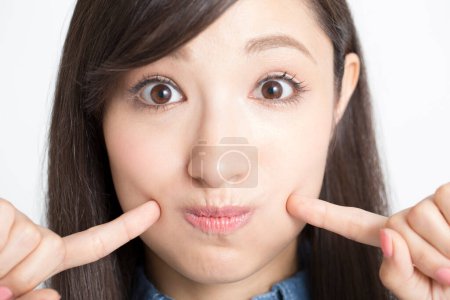 Photo for Young asian woman touching her face with fingers - Royalty Free Image