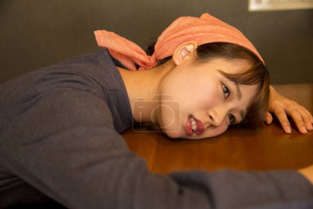 Photo for Tired asian woman in a cafe - Royalty Free Image