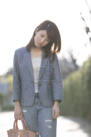 Téléchargez les photos : Asiatique triste femme portant une veste debout en ville - en image libre de droit