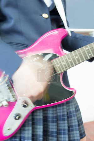 Foto de Asiático adolescente chica jugando guitarra en aula - Imagen libre de derechos