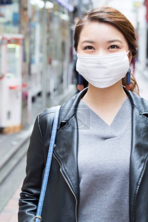 Photo for Asian woman wearing a face mask at the train station in japan. travel and tourism - Royalty Free Image