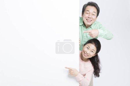 Foto de Retrato senior asiático pareja apuntando whiteboard - Imagen libre de derechos