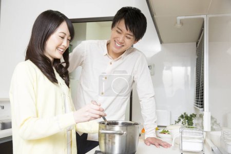 Photo for Young asian couple cooking together in the kitchen - Royalty Free Image