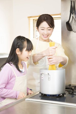 Photo for Mother and daughter cooking spaghetti - Royalty Free Image