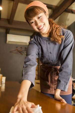 Photo for Asian woman waitress wiping table - Royalty Free Image