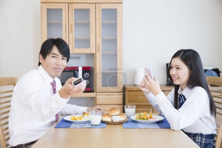 Téléchargez les photos : Portrait d'un jeune couple au petit déjeuner - en image libre de droit