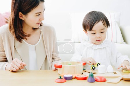Foto de Linda chica asiática jugando con la madre en casa - Imagen libre de derechos