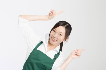 Téléchargez les photos : Jeune cuisinière pointant vers le haut isolé sur fond blanc - en image libre de droit