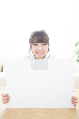 Téléchargez les photos : Asiatique femelle étudiant montrant vide blanc tableau - en image libre de droit