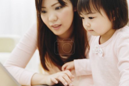 Photo for Asian woman and child are using laptop - Royalty Free Image