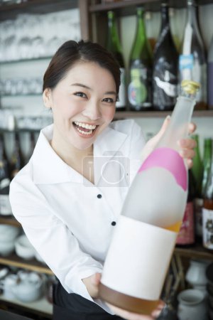 Téléchargez les photos : Asiatique serveuse femme avec une bouteille de boisson - en image libre de droit