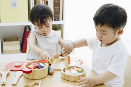 Foto de Lindos niños japoneses jugando con juguetes en casa - Imagen libre de derechos