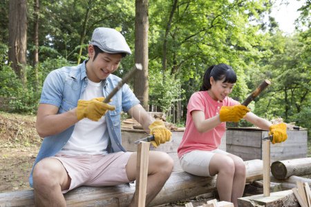 Téléchargez les photos : Les jeunes asiatiques préparent le bois pour le feu de joie. Les gens qui aiment camper à la nature - en image libre de droit