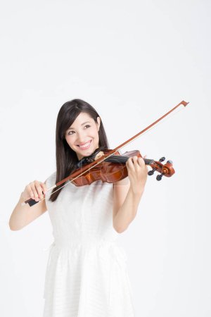 Photo for Smiling young beautiful asian woman playing violin  isolated on white background - Royalty Free Image