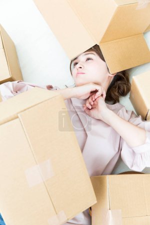 Photo for Young woman with cardboard boxes o floor - Royalty Free Image