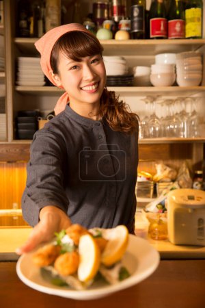 Photo for Young woman chef serving food at restaurant - Royalty Free Image