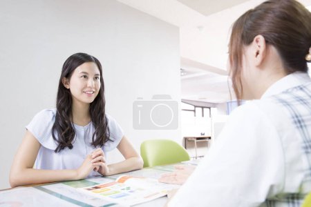 Photo for Portrait of young asian woman talking with consultant at driving school - Royalty Free Image