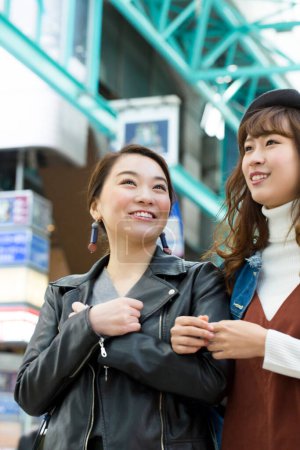 Téléchargez les photos : Deux jeunes femmes faisant du shopping en ville - en image libre de droit
