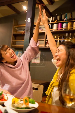Photo for Young beautiful asian women giving high five each other - Royalty Free Image