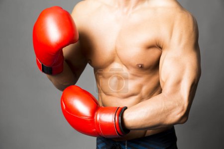 Téléchargez les photos : Jeune homme sportif avec des gants de boxe rouges - en image libre de droit