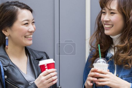 Foto de Asiático las mujeres beber café en calle - Imagen libre de derechos