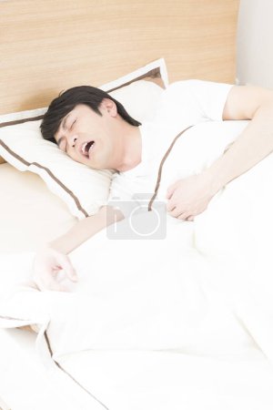 Foto de Asiático hombre durmiendo en la cama - Imagen libre de derechos