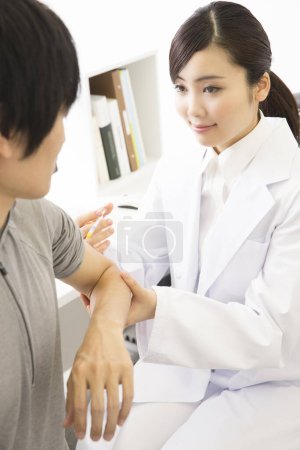 Téléchargez les photos : Asiatique médecin faire injection à jeune femme - en image libre de droit