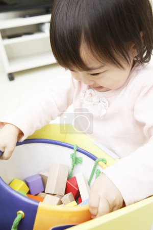 Foto de Pequeña asiática chica jugando con juguetes en la caja - Imagen libre de derechos