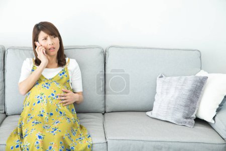 Foto de Retrato de joven asiática embarazada utilizando smartphone - Imagen libre de derechos