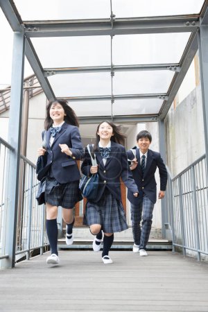 Photo for Portrait of young japanese students with bags in school - Royalty Free Image