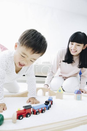 Téléchargez les photos : Mignon japonais garçon jouer avec mère à la maison - en image libre de droit