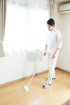 Téléchargez les photos : Homme nettoyage sol avec serpillière - en image libre de droit