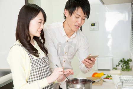 Foto de Joven asiático pareja cocinar juntos en la cocina - Imagen libre de derechos
