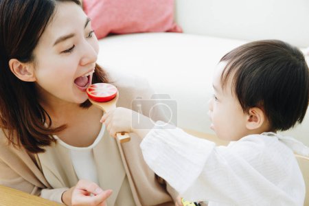 Foto de Linda chica asiática jugando con la madre en casa - Imagen libre de derechos