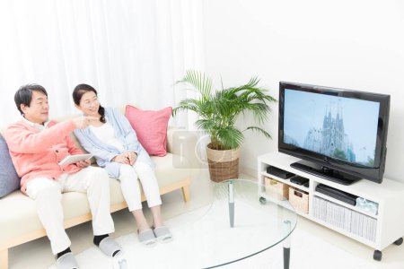 Photo for Senior couple watching tv on sofa - Royalty Free Image