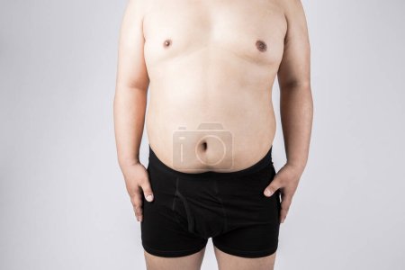 Téléchargez les photos : Gros avec un gros ventre. homme en surpoids. portrait studio - en image libre de droit