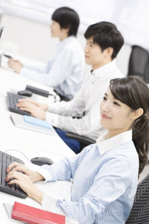 Téléchargez les photos : Jeunes gens d'affaires travaillant sur des ordinateurs au bureau - en image libre de droit