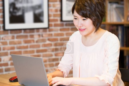 Téléchargez les photos : Asiatique femme avec ordinateur portable dans bureau - en image libre de droit